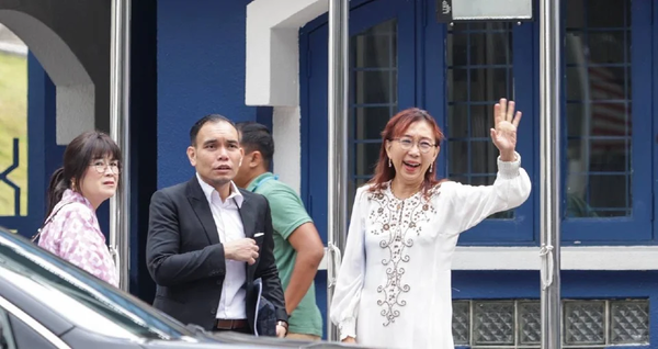 Syahredzan Johan (middle) accompanying Teresa Kok (right) while her statement was being taken at Bukit Aman yesterday.