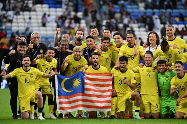 Harimau Malaya players and team members pose for a group photograph at the end of the Qatar 2023 AFC Asian Cup Group E football match.