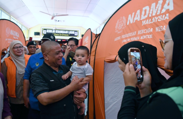 Perak Menteri Besar Datuk Seri Saarani Mohamad (second from left) comforting a flood victim during his visit to the Temporary Evacuation Centre at Sekolah Kebangsaan Lasah on Tuesday, 15 October.