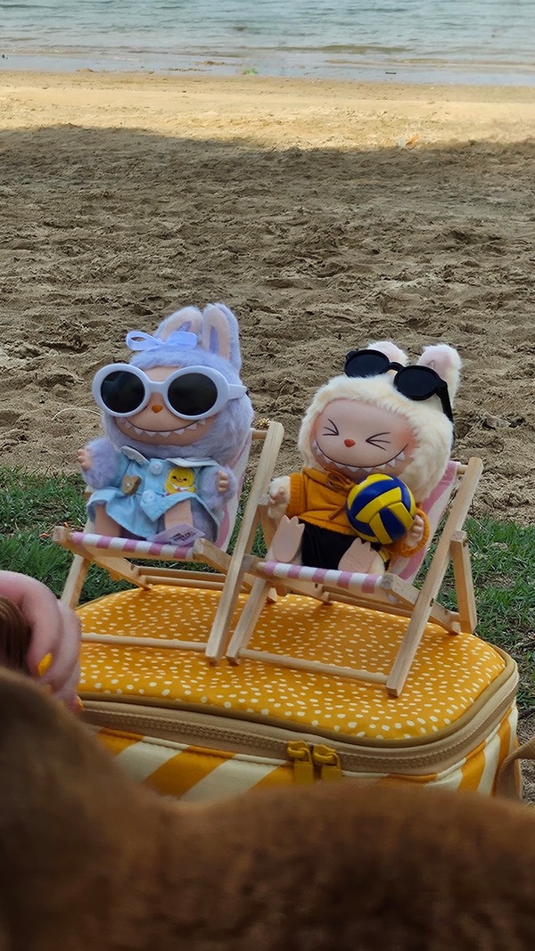 Manda and her friend pose their Labubus together at the beach.