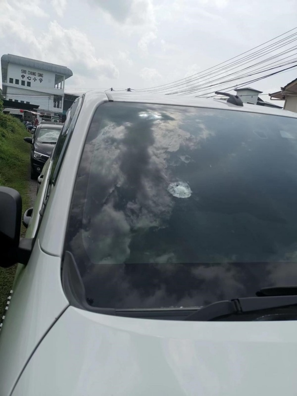 A bullet hole in the victim's car windscreen.