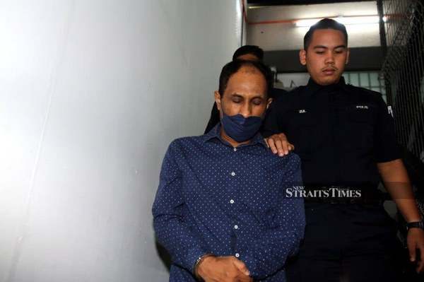 The accused, Rosman Jamaluddin, being escorted at the court compound last month.