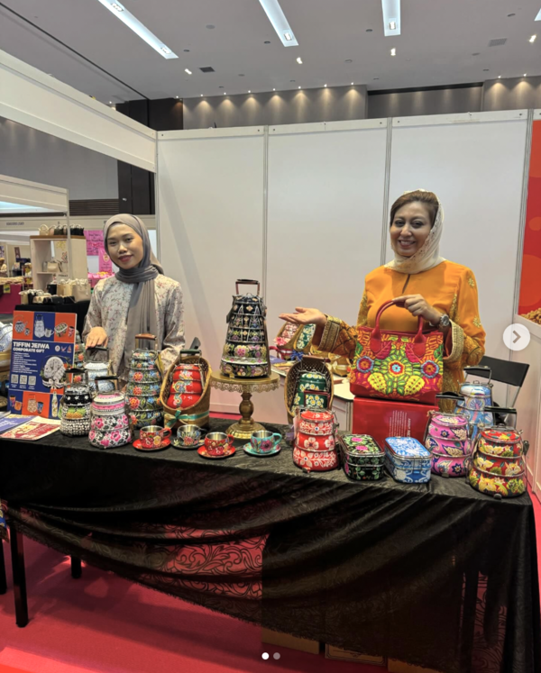 Penaung Tiffin Jeiwa Ina Fadilah Nizar (kanan) bersama pembantunya Nur Amiratul Farahin Ab Rahman menunjukkan produk keluaran syarikatnya pada Karnival Usahawan Wanita Malaysia 2024 baru-baru ini.