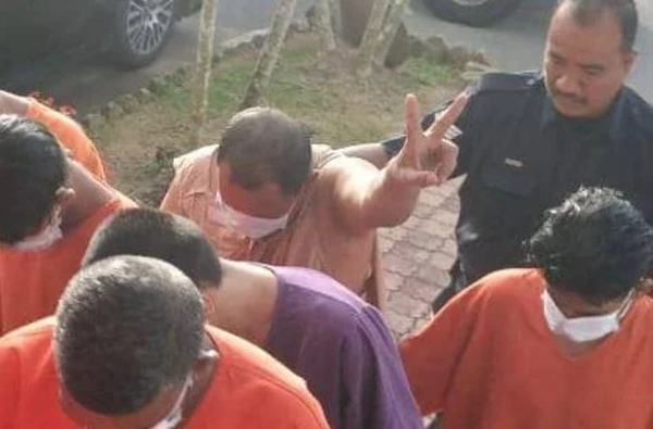 The 51-year-old lorry driver, Marhizan Johari, flashed a peace sign when he was brought to court.