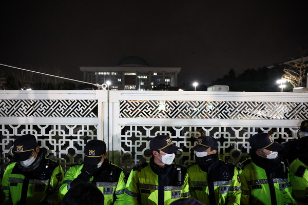 Police officers stand guard at the gate of the National Assembly after South Korean President Yoon Suk Yeol declared martial law in Seoul.