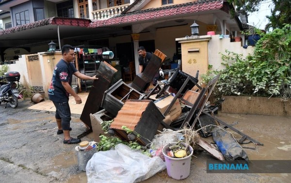 Residents of Arena Kepayang Putra cleaning up after the flood.