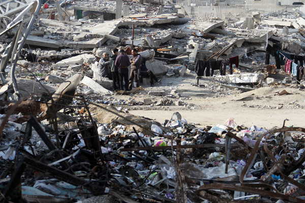 Palestinians stand among the rubble of houses destroyed in previous Israeli strikes, amid ceasefire negotiations with Israel, in Gaza on 15 January.