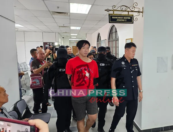 Soo Siau Soon being escorted into the Johor Bahru Magistrate's Court.