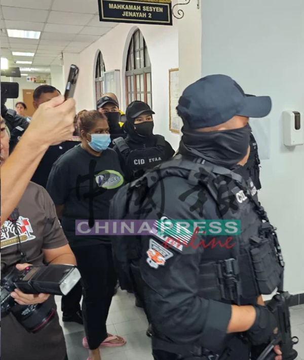 C Susila being escorted into the Johor Bahru Magistrate's Court.