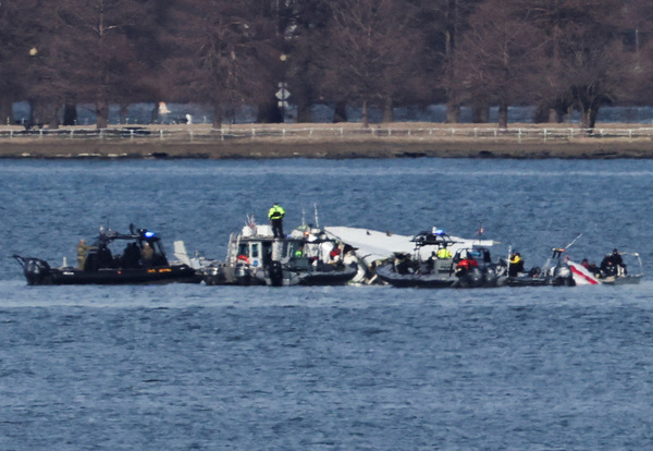 Emergency workers recover debris from the Potomac River in the aftermath of the collision of American Eagle flight 5342 and a Black Hawk helicopter, as seen from Virginia, U.S., 30 January, 2025.