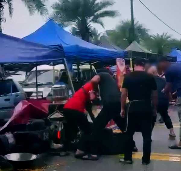 Tangkap layar memaparkan beberapa individu memukul lelaki OKU mental yang dikatakan terlanggar sebuah gerai di Pasar Tani.