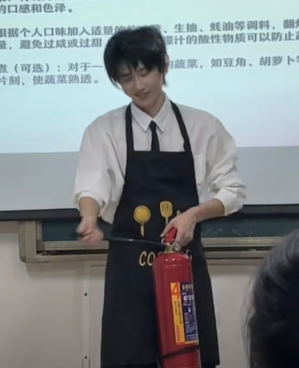 Fu teaching his students how to use a fire extinguisher.