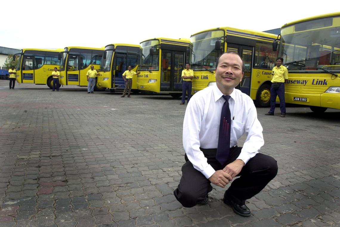 Lim Han Weng ketika muda bergambar di hadapan bas-basnya selepas memperoleh lesen pada 2003 untuk menjalankan perkihdmatan bas rentas sempadan di bawah jenama Causeway Link.