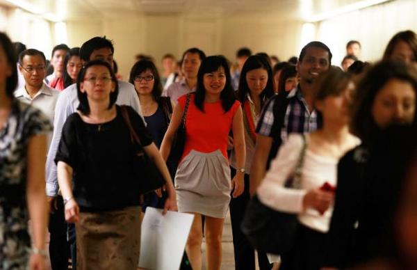 Commuters walk inside the Raffles Place MRT station during rush hour at the central business district area in Singapore.