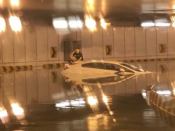 Man sits on car in KL after flood