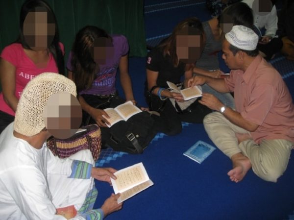 JAKIM Family, Social, and Community Development director Zakuan Sawai (right) reading the Quran with transgender women at the camp in 2011.