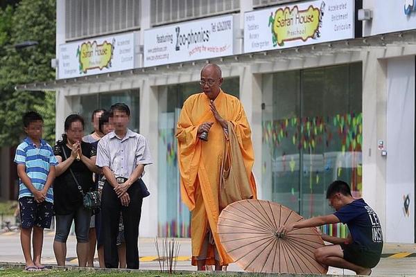 Jia He's family observing a priest performing rites near 11 Woodlands Close, where the tragedy occurred.