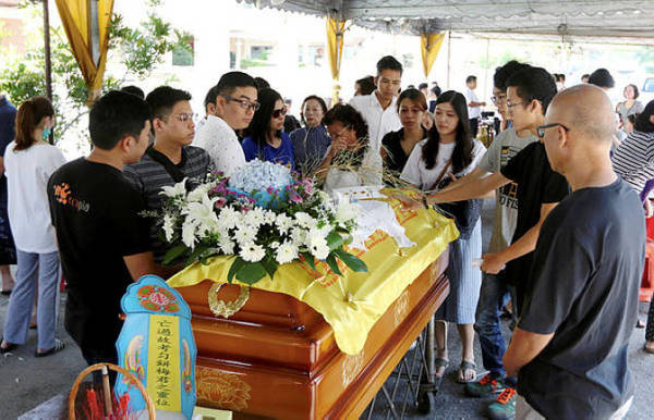 Family and friends of accident victim Moey Yun Peng paying their last respects at the Berapit Chinese cemetery in Penang.