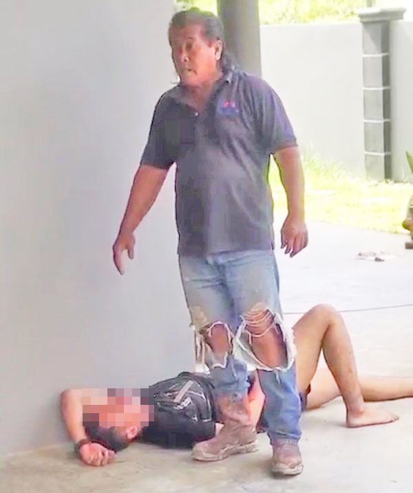 Owner of the house standing beside the badly beaten up burglar.