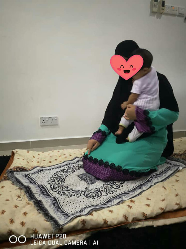 Cara ibu mendukung anak ketika dalam solat semasa tahiyat awal atau akhir.