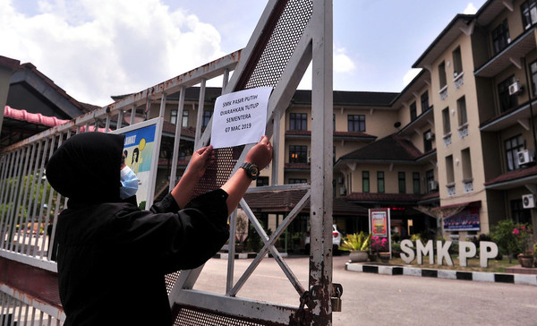 A notice being put up in front of SMK Pasir Putih to announce the temporary closure of the school due to toxic fumes from chemicals dumped into the nearby Sungai Kim Kim, March 7.