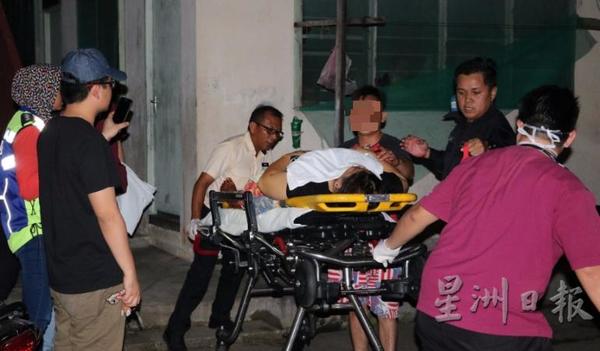 The victim being accompanied by the 28-year-old man (third from right) to the ambulance.