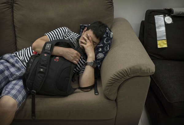 chinese man sleeping on brown ikea couch