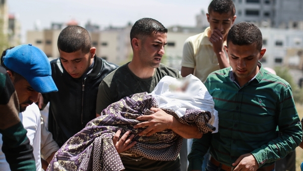 A Palestinian man holding a deceased baby following bombing in the Gaza Strip on Saturday, 4 May.