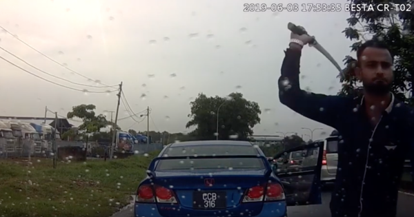 Screengrab showing the main suspect attacking a car with a parang on Monday.