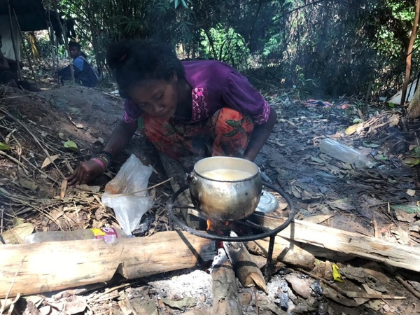 A woman cooking rice with water from Sungai Pertang, a stream located near Kuala Koh.