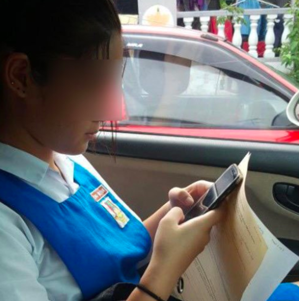 The student holding copies of the police report in her mother's car.