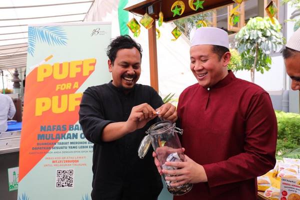 Singapore Health and Home Affairs senior parliamentary secretary Amrin Amin collecting cigarette sticks from smokers.