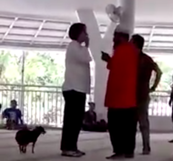 The woman arguing with worshippers while the dog runs loose.