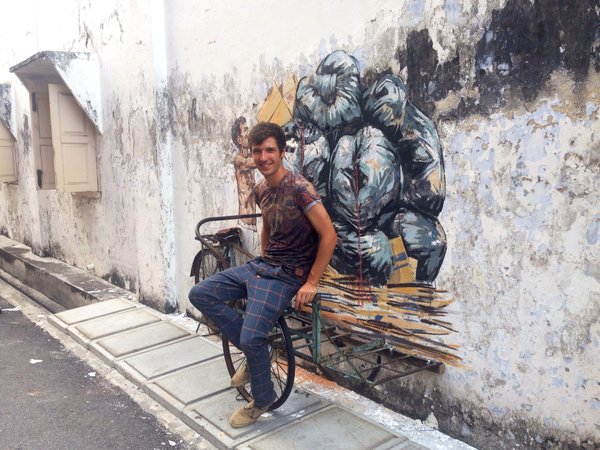 Ernest Zacharevic with one of his murals in Ipoh.