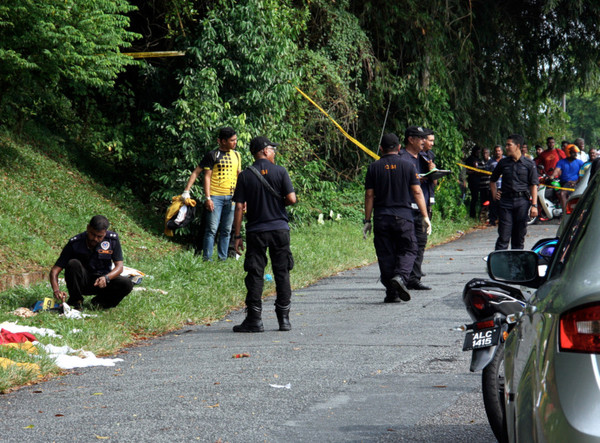 Authorities inspecting the crime scene yesterday after discovering the victim's body.