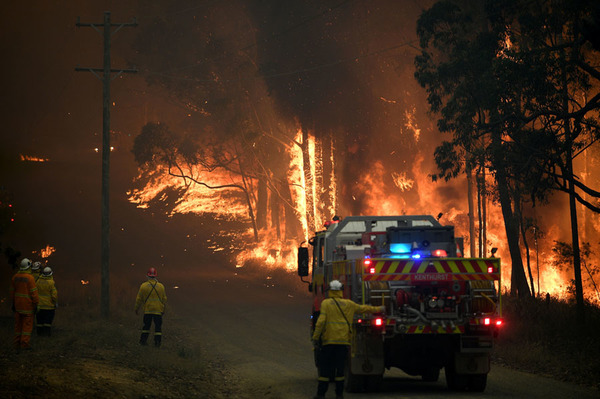 New South Wales Rural Fire Service fights a fire as it burns close to a property northwest of Sydney on 19 November.