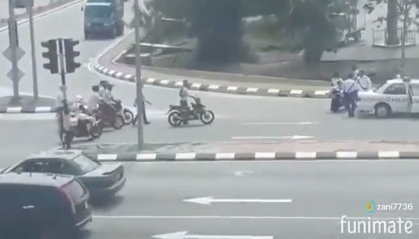 Police controlling the situation after the group was found causing a nuisance at Klebang, Melaka.