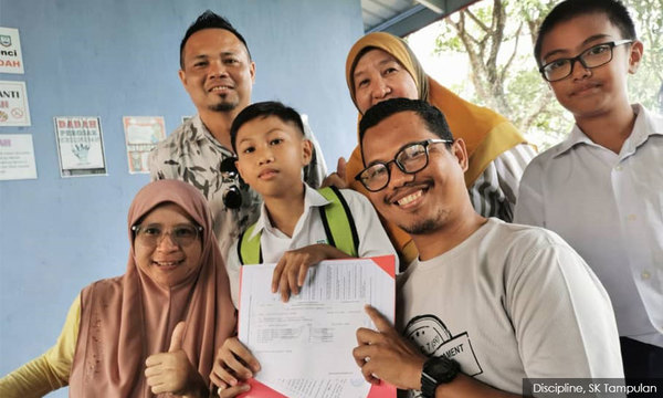 (In the middle) Edjucchio Effour Edmund holding his UPSR results.