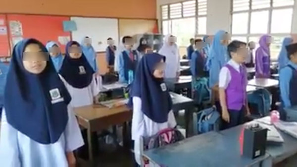 Primary school students singing 'Negaraku' in Arabic.