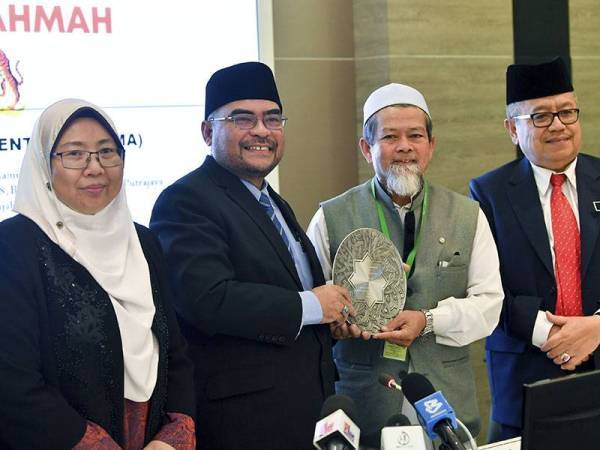 Religious Affairs Minister Datuk Seri Dr Mujahid Yusof awarding Abdul-Munim Sombat Jitmoud the Rahmatan Lil Alamin Icon.