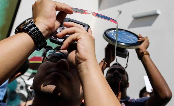 Visitors looking at the annular solar eclipse during a viewing in Penang today, 26 December.