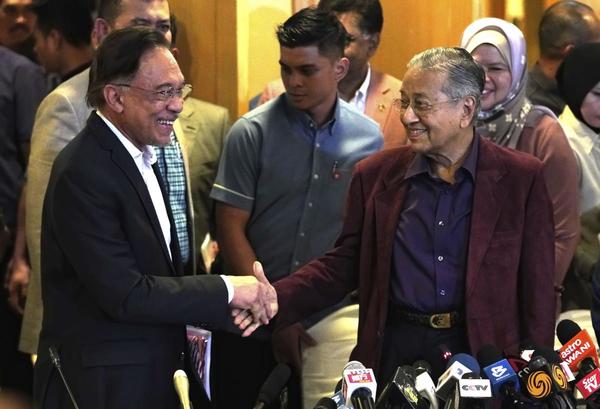 Dr Mahathir shakes hand with Anwar in Putrajaya on 22 February.