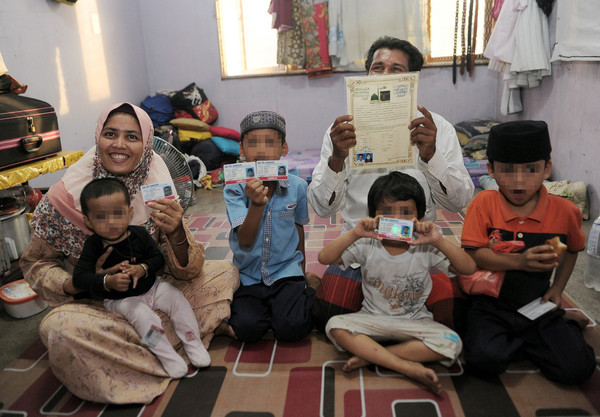 A Rohingya family shows their new UNHCR cards.