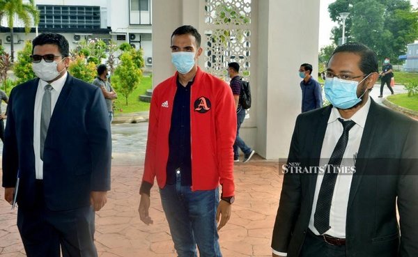 Photo, dated 29 April, shows Hazrul Hizham (centre) arriving at the Klang Session's court.