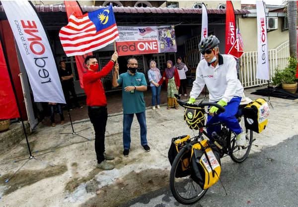 Daniel Leoh (left) and Zabidi Ishar (right) flagging off Pak Wan in front of his home in Kota Bharu.