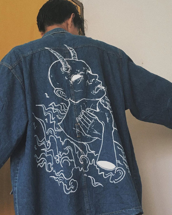 A custom denim jacket called 'Suffocating', featuring their original character 'uncle Bo'.