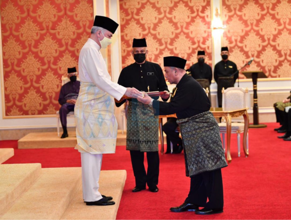 Perak BN chairman Datuk Saarani Mohaman (right) taking his oath of office as the 14th Perak MB.