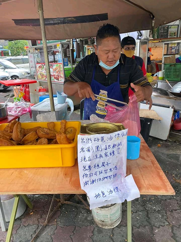 A note at his stall reads, "We are Hao Ba You Tiao. I just came from Johor Bahru and I don't have a house to live in. I need to rent a house. Can you help me?"