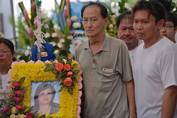 The husband (in grey) of the victim, and one of their two sons at the wake.