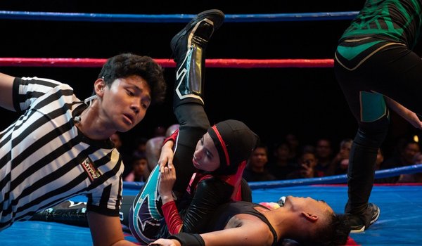 Nor Diana wrestling with a male opponent during a match in Kuala Lumpur.